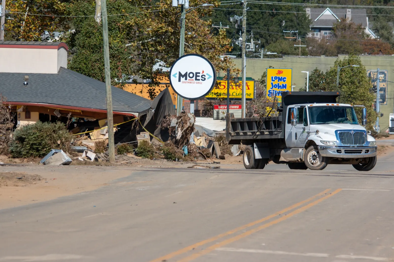 A dump truck on a debris-strewn street in Biltmore Village.