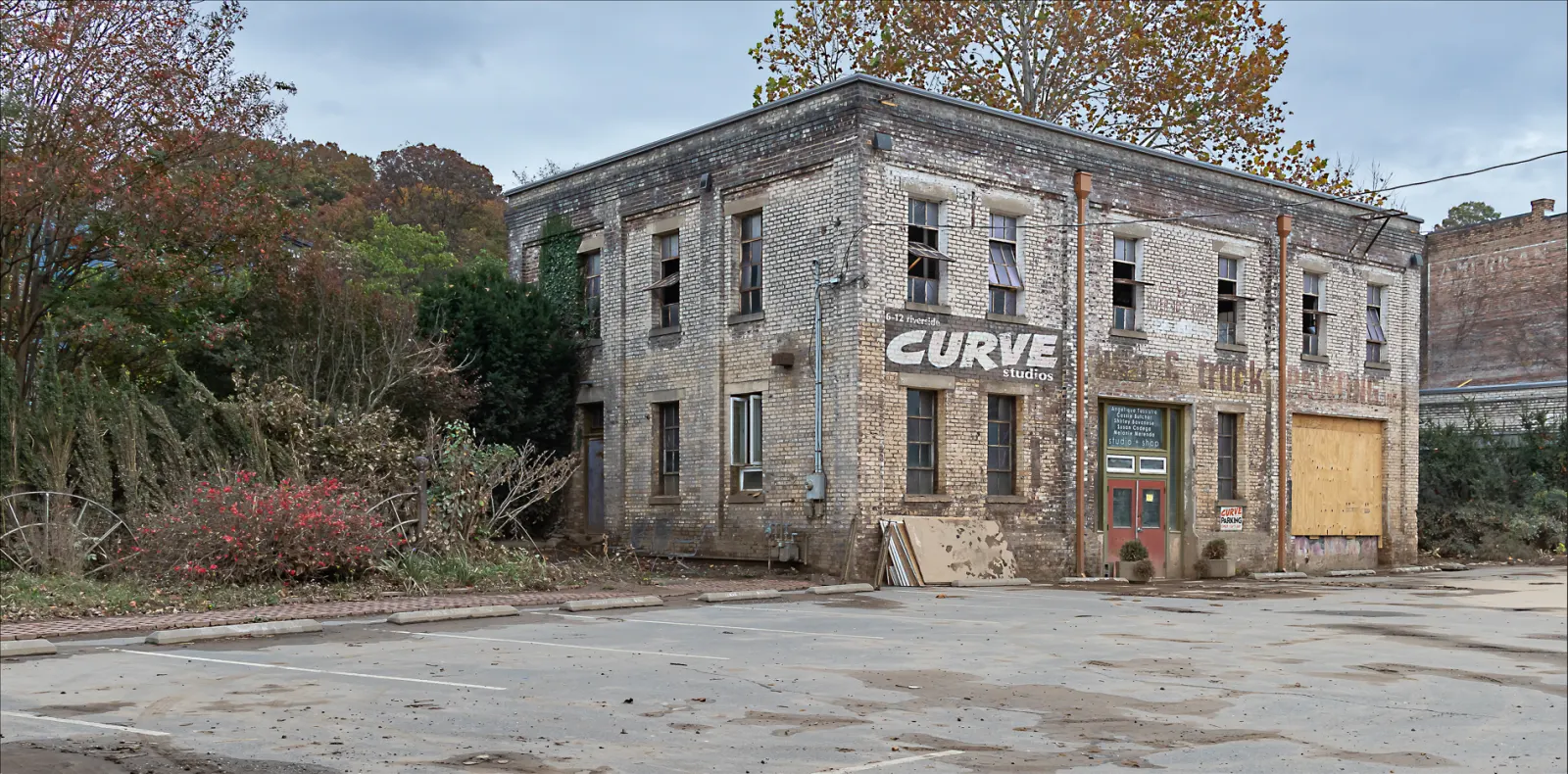A damaged building in the River Arts District with debris piled in front of it.